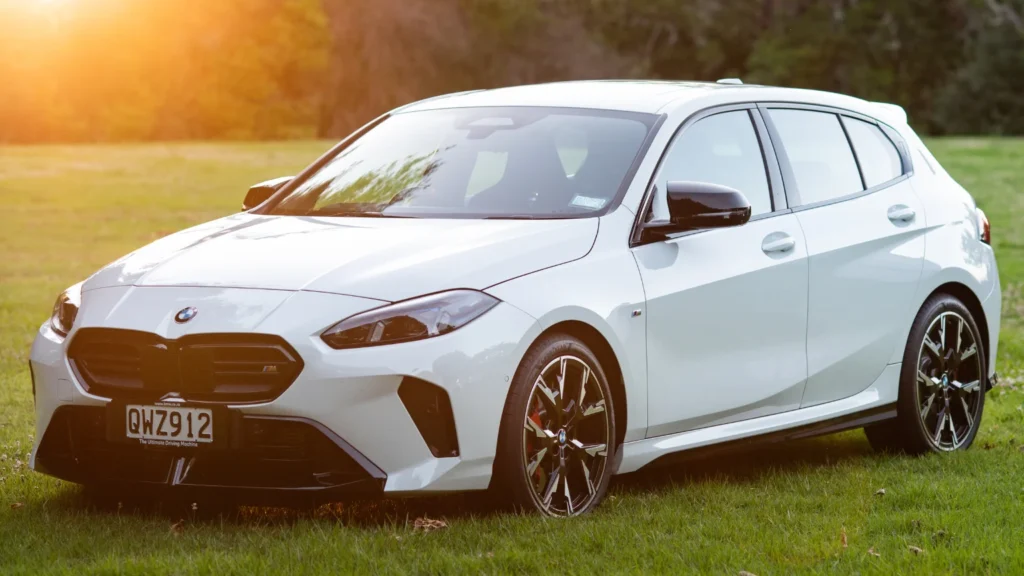 Side profile of the BMW M135i with sunlight flare highlighting its hatchback proportions