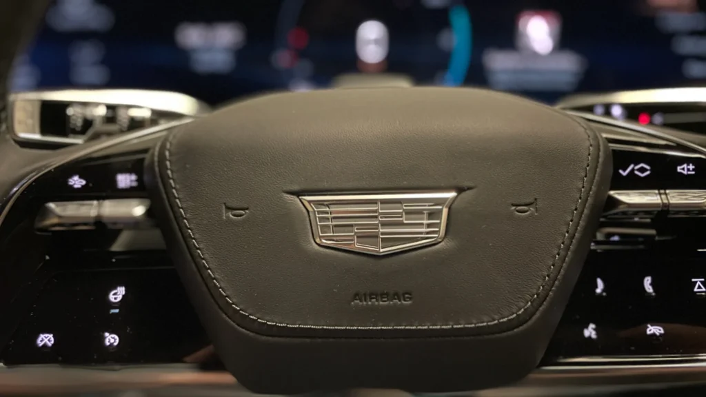 Close-up of the Cadillac steering wheel with illuminated crest and touch controls