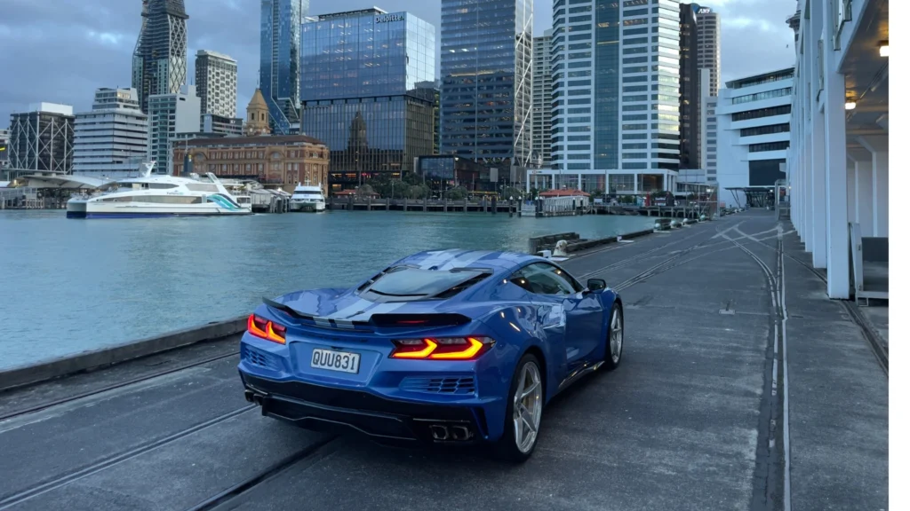 Rear three-quarter view of the Chevrolet Corvette E-Ray showing wide stance and LED tail lights by the waterfront