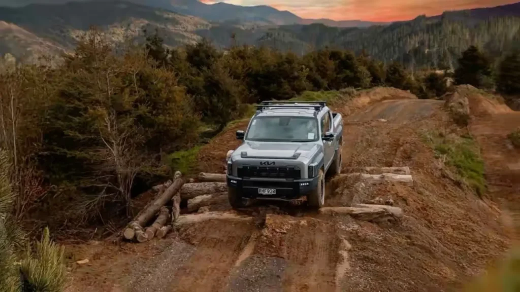Kia Tasman driving over logs during off-road testing in New Zealand
