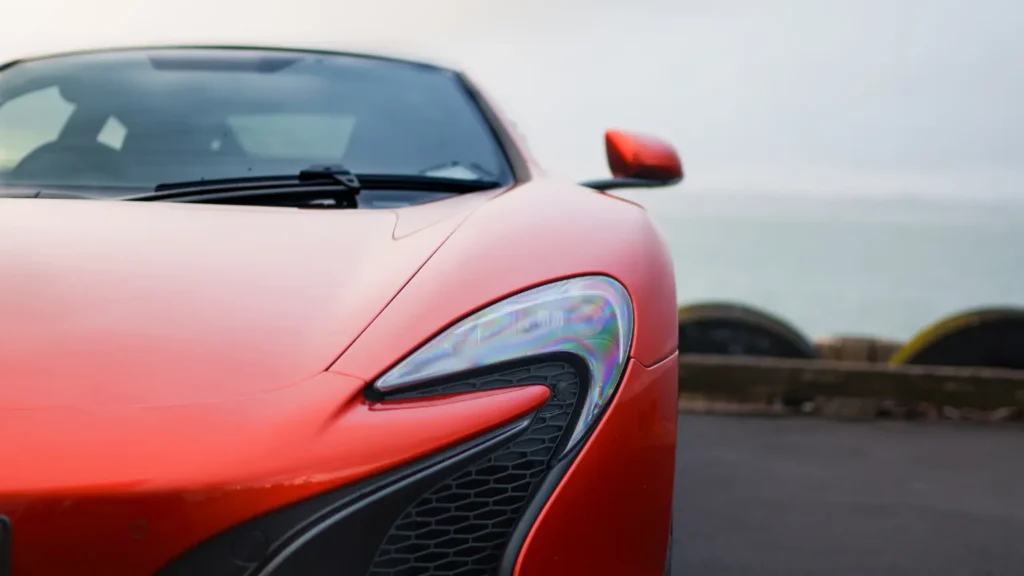 Close-up of the front headlight and grille of a red McLaren 650S