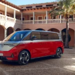 Red Volkswagen ID.Buzz electric van parked in a courtyard showing modern Kombi design