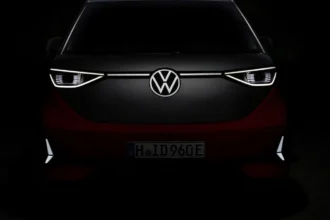 Front view of Volkswagen ID.Buzz with illuminated LED headlights and VW badge