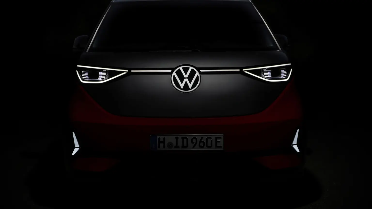 Front view of Volkswagen ID.Buzz with illuminated LED headlights and VW badge