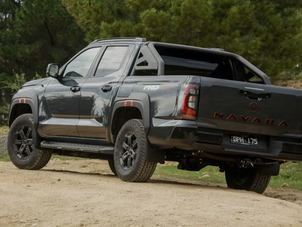 Rear side view of 2026 Nissan Navara Pro-4X parked outdoors showing tailgate and off-road design