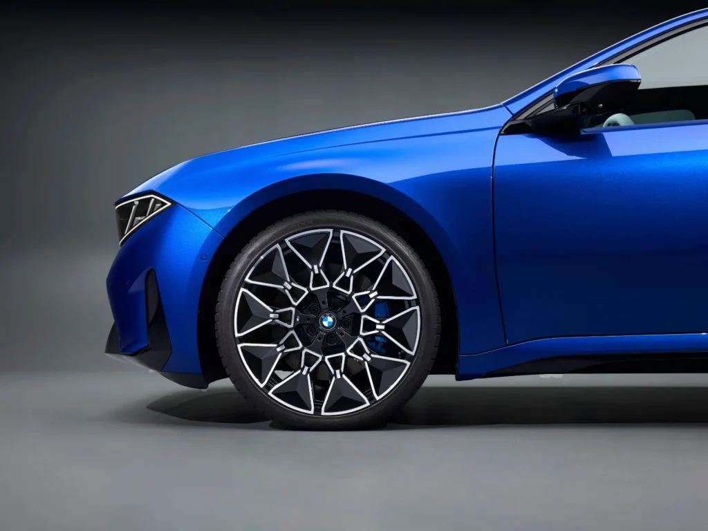 BMW i3 alloy wheel and front quarter panel detail in metallic blue with blue brake caliper accents