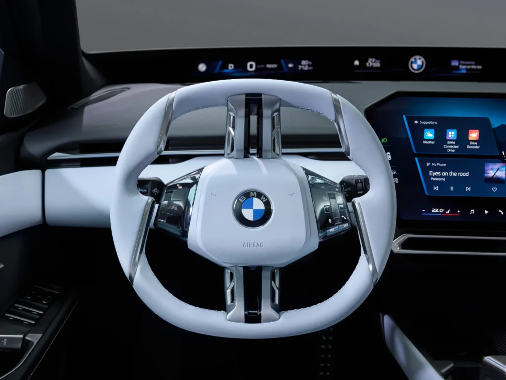 BMW i3 white leather steering wheel with Panoramic iDrive infotainment display in the background
