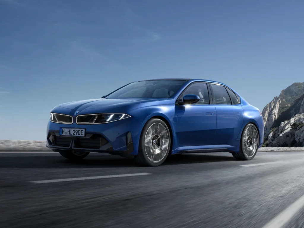 BMW i3 fully electric 3 Series in blue driving on an open road with mountain scenery