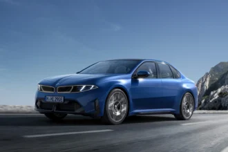 BMW i3 fully electric 3 Series in blue driving on an open road with mountain scenery