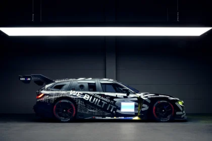 BMW M3 Touring race car side view in a studio with “We Built It” livery and large rear wing
