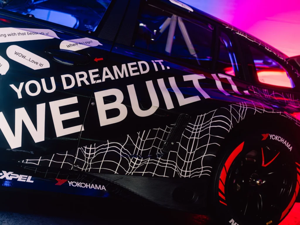 Close-up of BMW M3 Touring side livery showing “We Built It” text and Yokohama tires