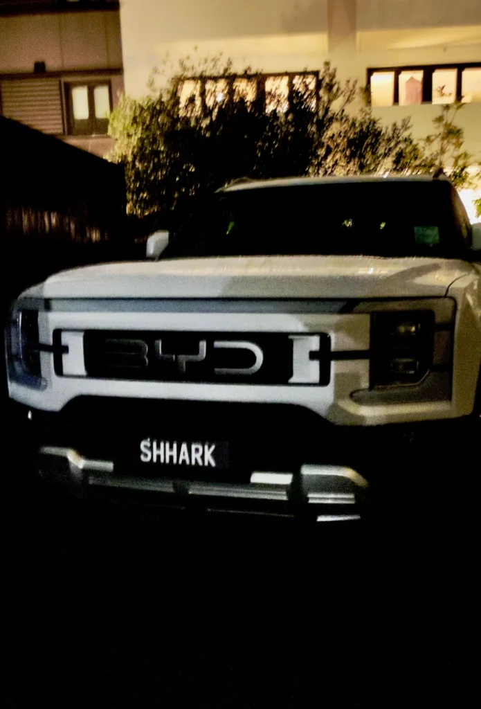 BYD Shark 6 front grille night shot with illuminated badge